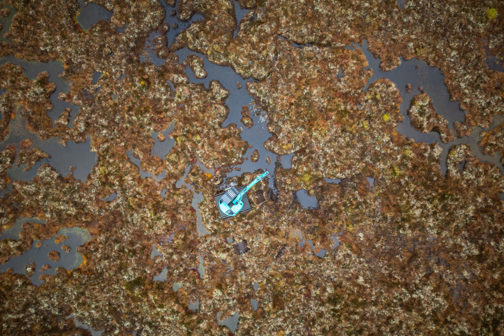 An excavator carrying out peatland restoration on a degraded peatland ecosystem. Dundreggan Estate, Affric Highlands.